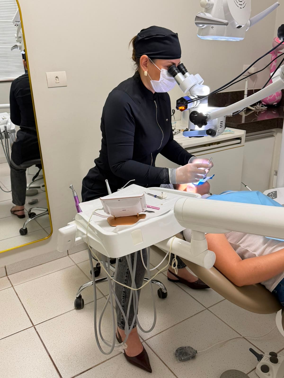 Dra. Pâmela em atendimento com microscópio operatório